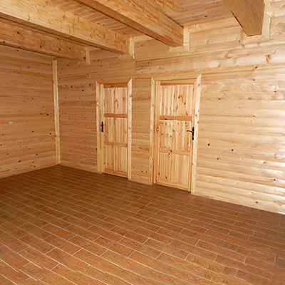 wnętrze salonu, ściany z desek, na suficie widać legary, podbitka również drewniana.